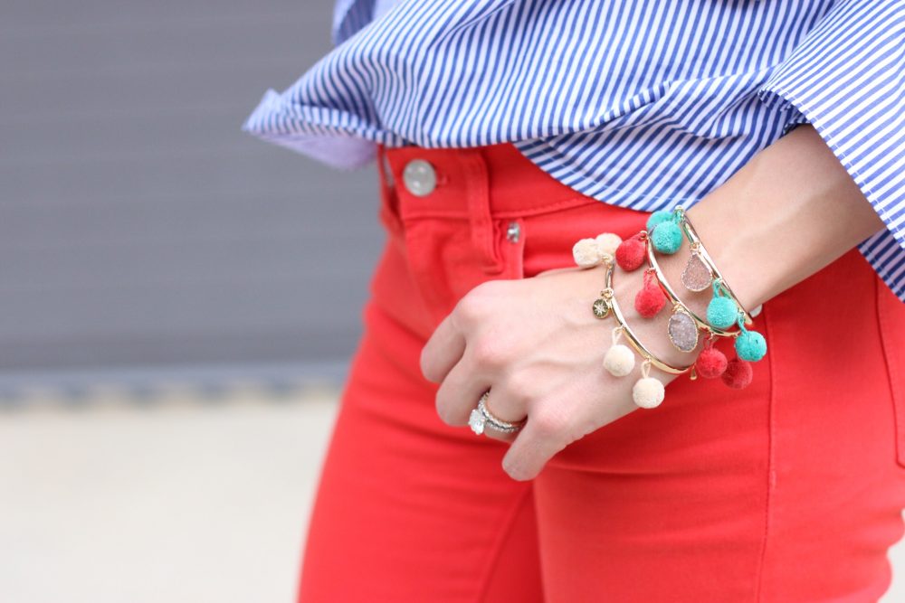 Pompom Bracha bracelets and bright red pants